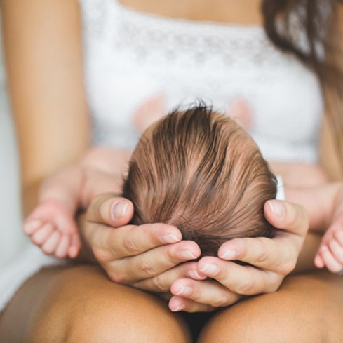 newborn being held on their mother’s lap