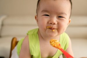 an infant being fed a spoonful of food 