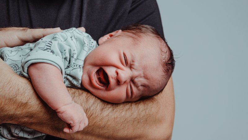 a person holding a crying baby