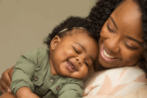 Woman smiling while holding her happy child
